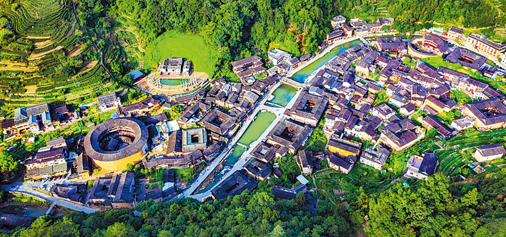 Vue plongeante des bâtiments de terre dans le comté de Nanjing de la province du Fujian, au milieu de forêts et de terres agricoles en gradins. HUANG QIUHUA / FOR CHINA DAILY