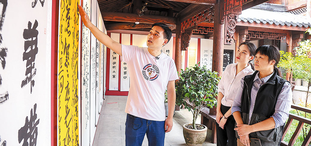 Des visiteurs discutant de calligraphie dans le village de Nanshan à Hangzhou. PROVIDED TO CHINA DAILY