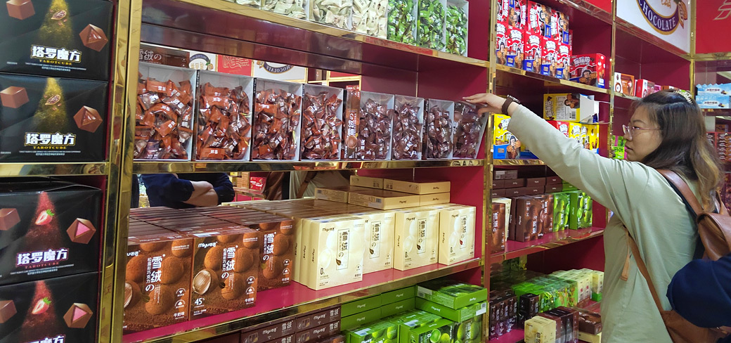 Une cliente passant en revue les produits de chocolat dans une boutique