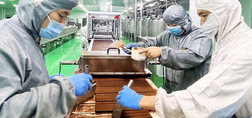 Des ouvriers sur une chaîne de production de chocolat