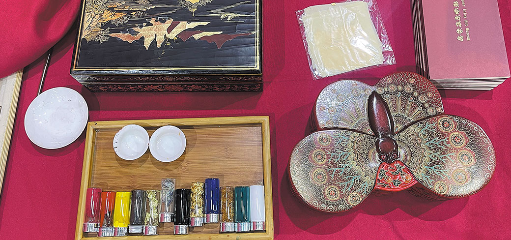 Des boîtes à bijoux et à bibelots décorées de motifs de paysages, d’oiseaux et de papillons donnaient de l’éclat à un stand présentant de la laque dorée. YANG FEIYUE / CHINA DAILY