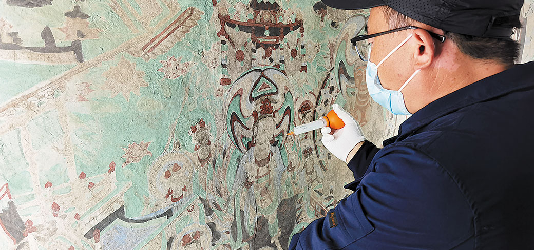 Un restaurateur de l’Académie de Dunhuang au travail sur des peintures murales de la grotte 55 de Mogao remontant au 10ème siècle. WANG KAIHAO / CHINA DAILY