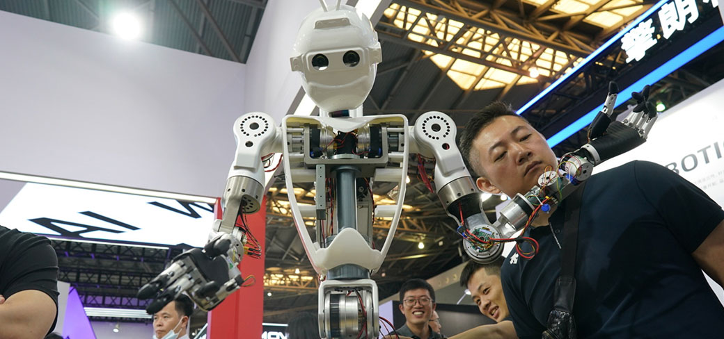 Un visiteur étudiant un robot à la Conférence mondiale sur l’intelligence artificielle à Shanghai en juillet. GAO ERQIANG / CHINA DAILY
