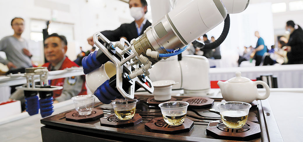 Un robot servant du thé aux visiteurs lors d’une exposition en avril à Pékin. WU CHANGQING / FOR CHINA DAILY