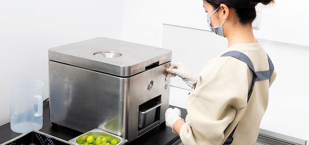Une employée de la société Heytea utilisant une éplucheuse automatisée pour récupérer la matière brute destinée à son thé au lait à base de raisin vert lors de la quatrième Exposition internationale des produits de consommation de Chine, qui s’est déroulée en avril à Haikou, dans la province du Hainan. PROVIDED TO CHINA DAILY