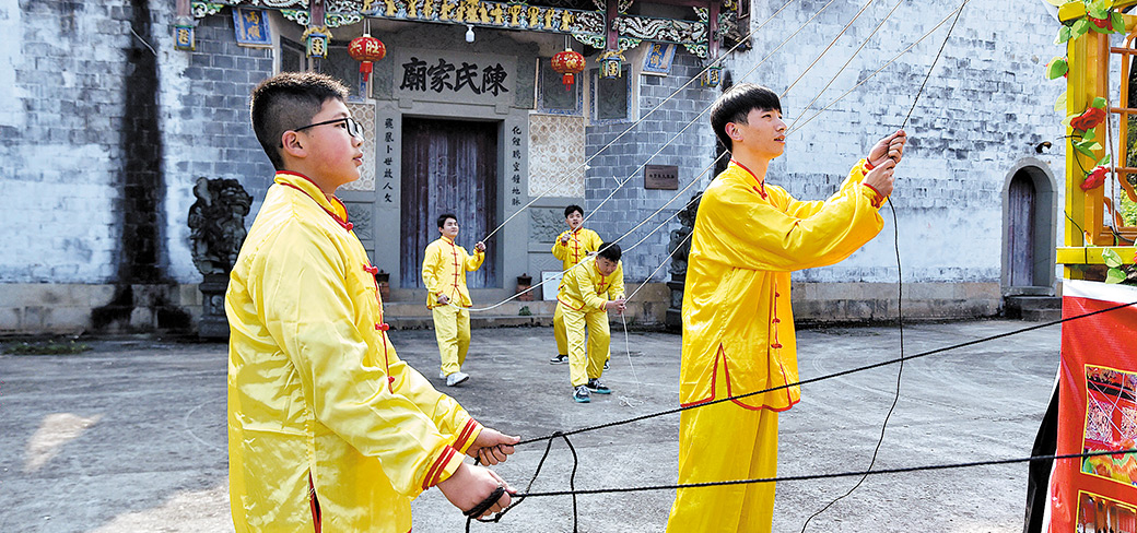 L’équipe de Chen au cours d’un essai des cordes avant un spectacle au village. PROVIDED TO CHINA DAILY