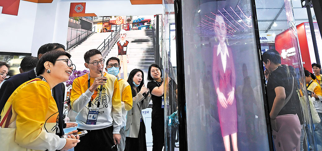 Le personnel expliquant aux visiteurs comment communiquer avec un avatar numérique lors de la conférence Apsara à Hangzhou, dans la province du Zhejiang, le 31 octobre 2023. LI ZHONG / FOR CHINA DAILY