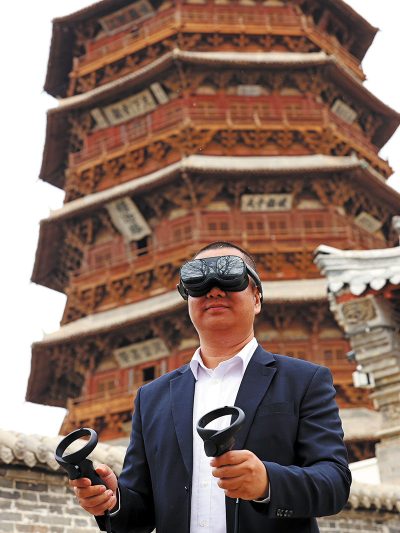 Un ouvrier fait l’expérience de « gravir » la pagode Sakyamuni à l’aide de la réalité virtuelle en avril. ZHU XINGXIN / CHINA DAILY