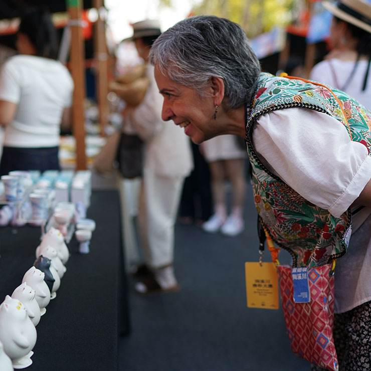 Une artiste étrangère regarde des œuvres en céramique lors d'un festival de la céramique organisé en marge du Salon international de la céramique de Jingdezhen 2025, dans la province du Jiangxi, dans l'est de la Chine, le 17 octobre 2025. (Xinhua/Zhou Mi)